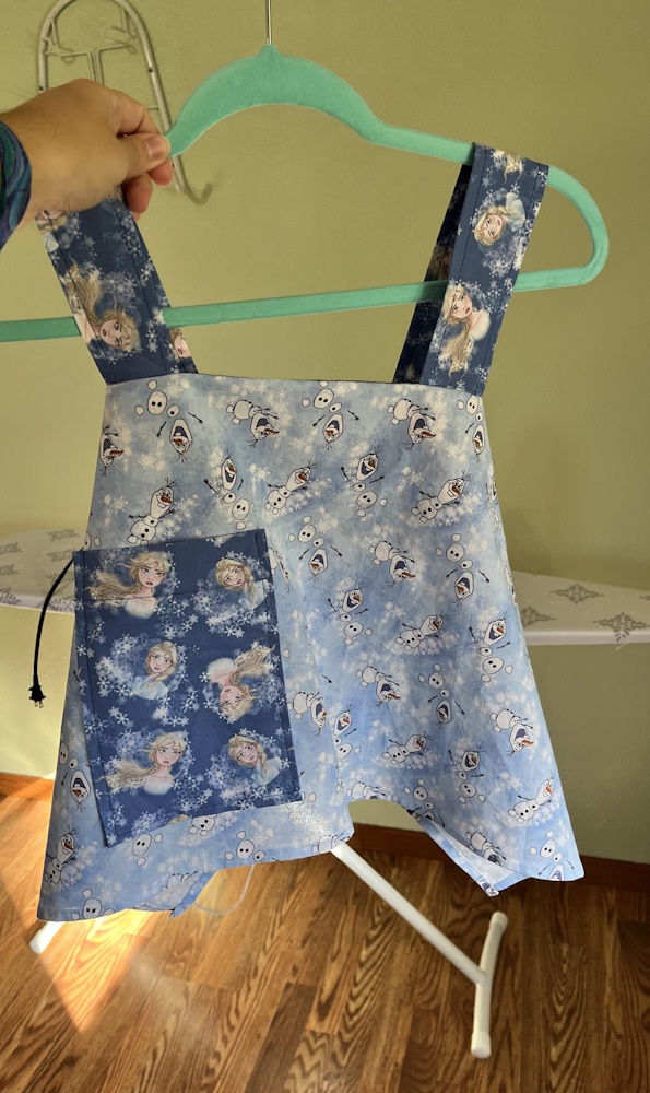 A slightly smaller child sized apron from a base of olaf fabric with elsa details